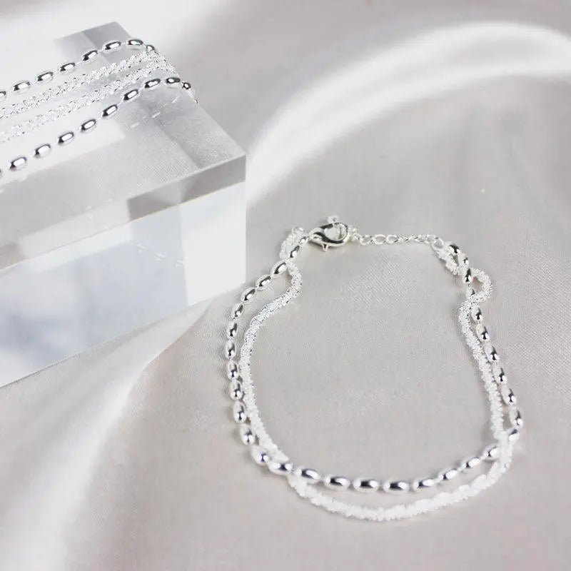 Conjunto de pulseras elegantes plateadas con piedras de circonia