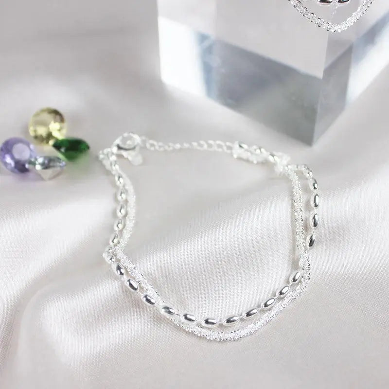Conjunto de pulseras elegantes plateadas con piedras de circonia