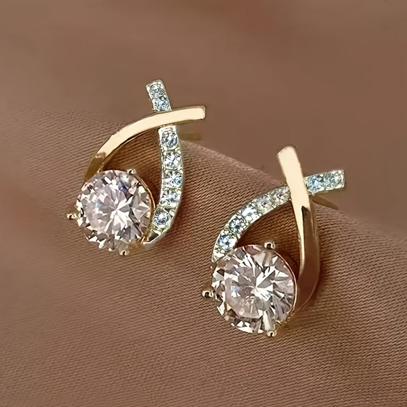 Pendientes tipo stud de cruz dorada con zirconia.